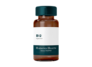 A bottle of B12 liquid next to a clear bottle of water on a white background.