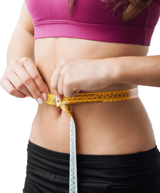 A woman measuring her waist with a tape measure, focusing intently on the measurement for fitness or health purposes.