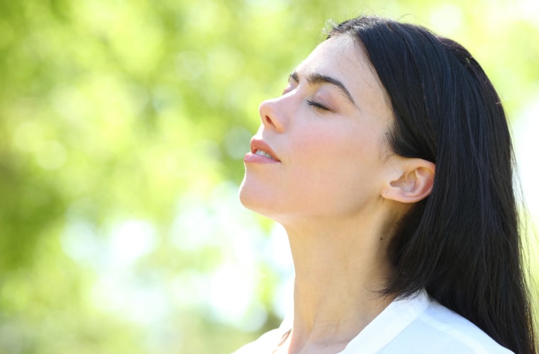 A woman with closed eyes breathing well