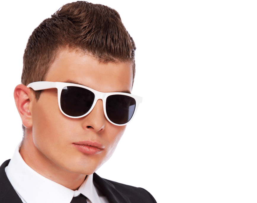 A man wearing a suit and sunglasses stands confidently, exuding a professional and stylish demeanor.