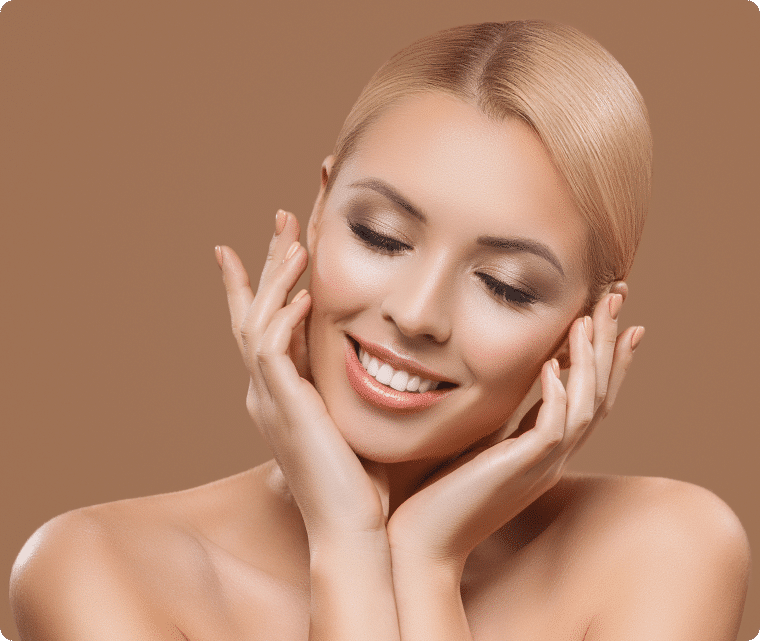 A woman with her hands on her face, expressing surprise or concern, with a neutral background.