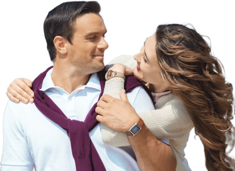 A man and woman embrace each other, smiling.