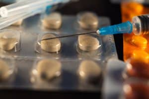 A closeup shot of pharmaceutical capsules, pills and syringes