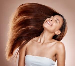 Hair care, beauty and woman in a studio with healthy, long and brown hair after a salon hair style