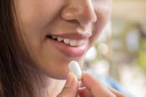 Young woman taking medicine pill after doctor order