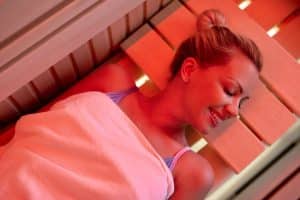 High angle view of smiling woman relaxing in sauna with her eyes closed.