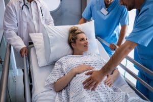 Team of doctors examining pregnant woman in the hospital