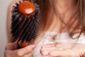 woman holding her hairbrush and hairfall