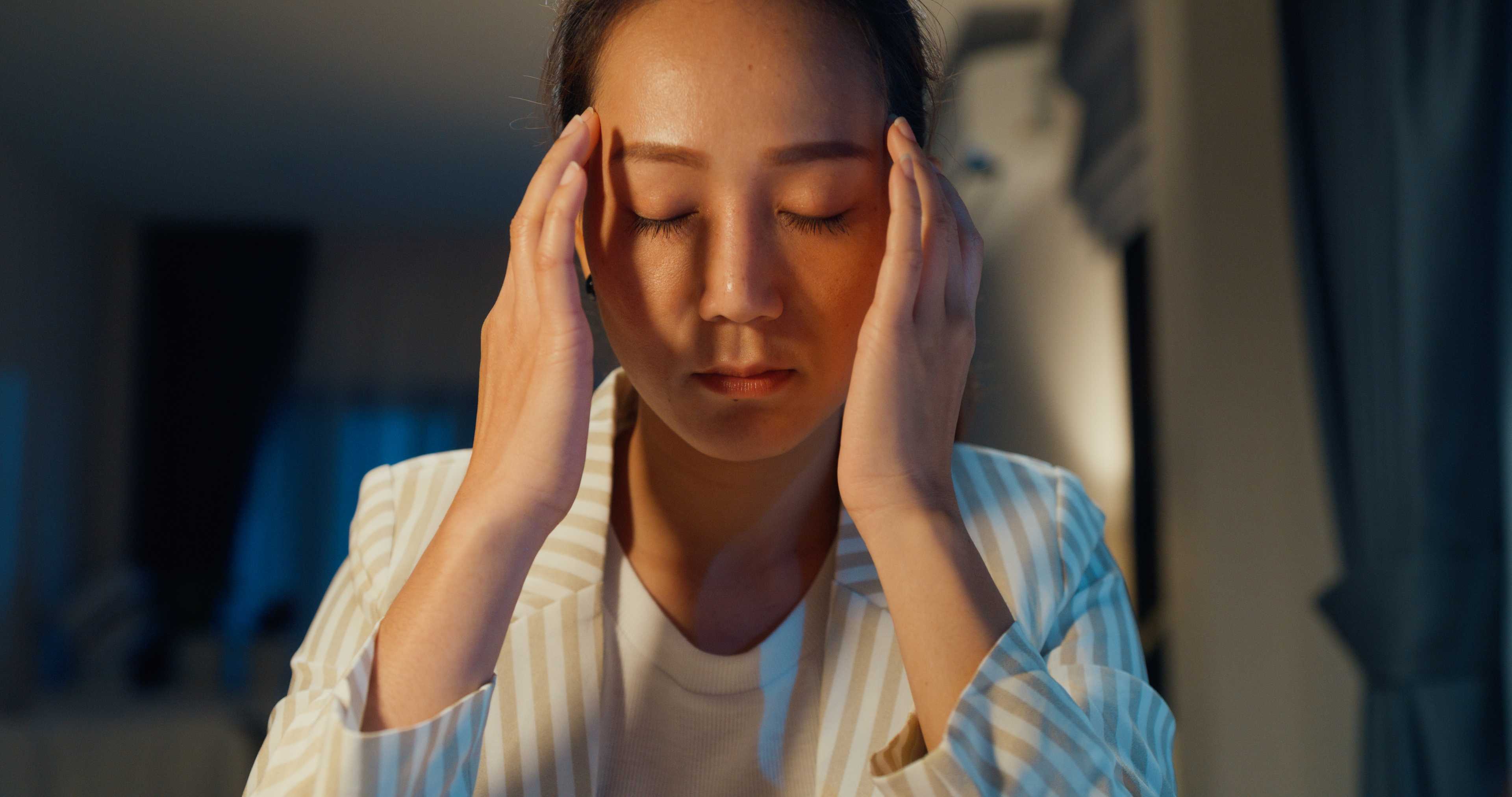 woman sitting on chair having mild headache