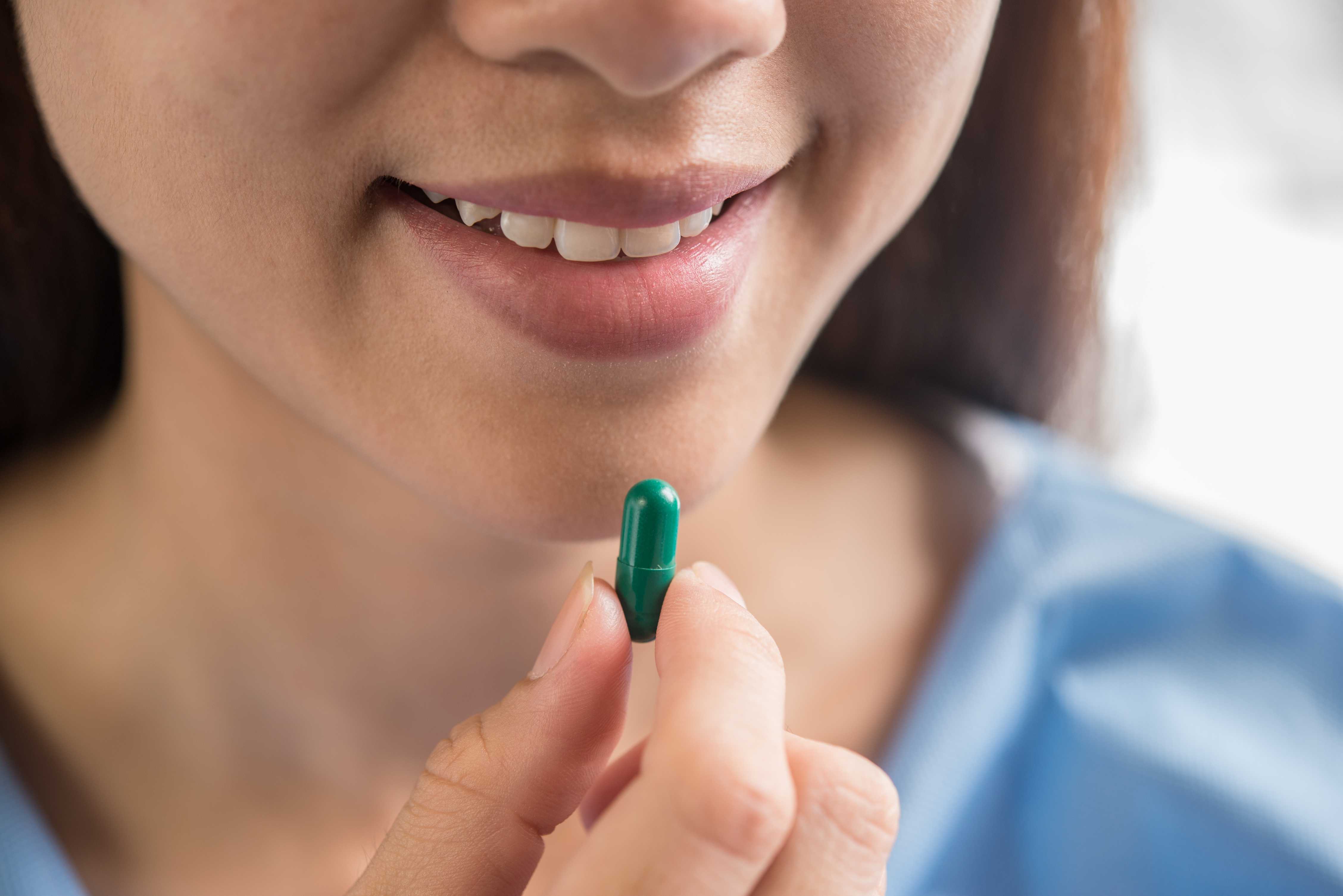 woman taking glutathione capsule