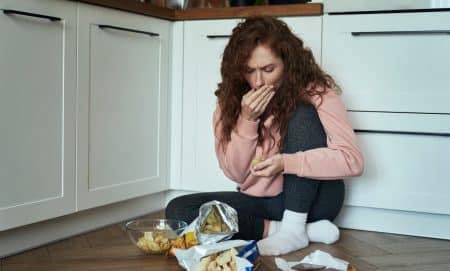 young woman emotionally overeating