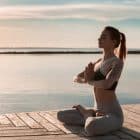 Picture of young sports lady at the beach make meditate exercises.