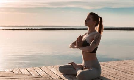 Picture of young sports lady at the beach make meditate exercises.