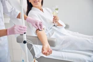 woman relaxing and getting an iv drip from a certified clinician